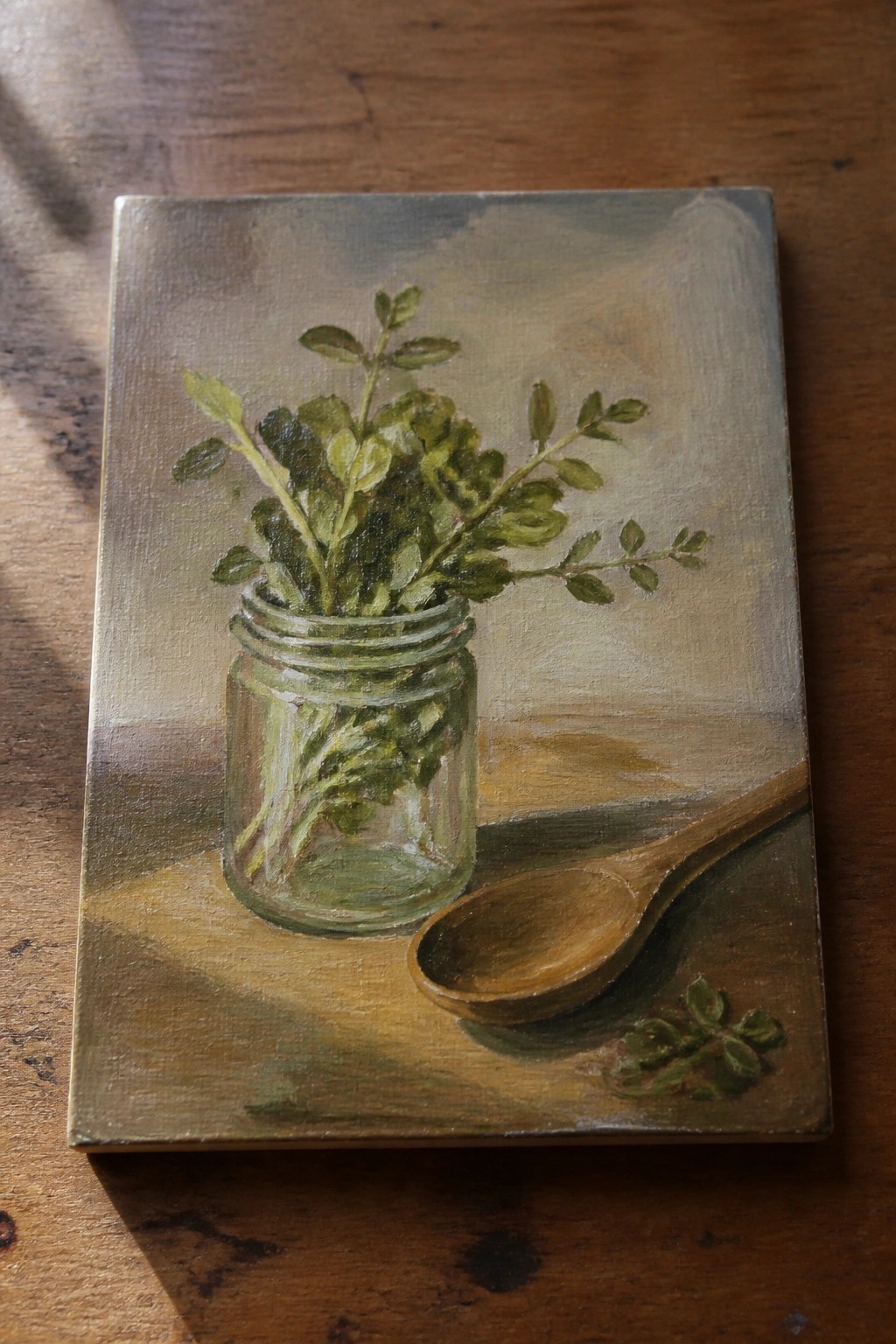 Still life painting of green herbs in a glass jar beside a wooden spoon