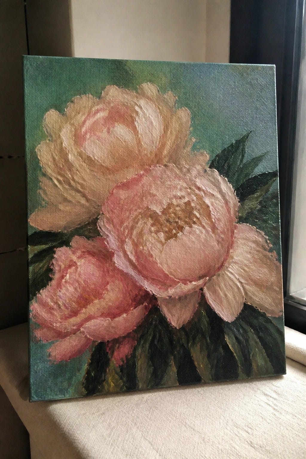 Canvas painting of pink peonies with green leaves on textured green background.