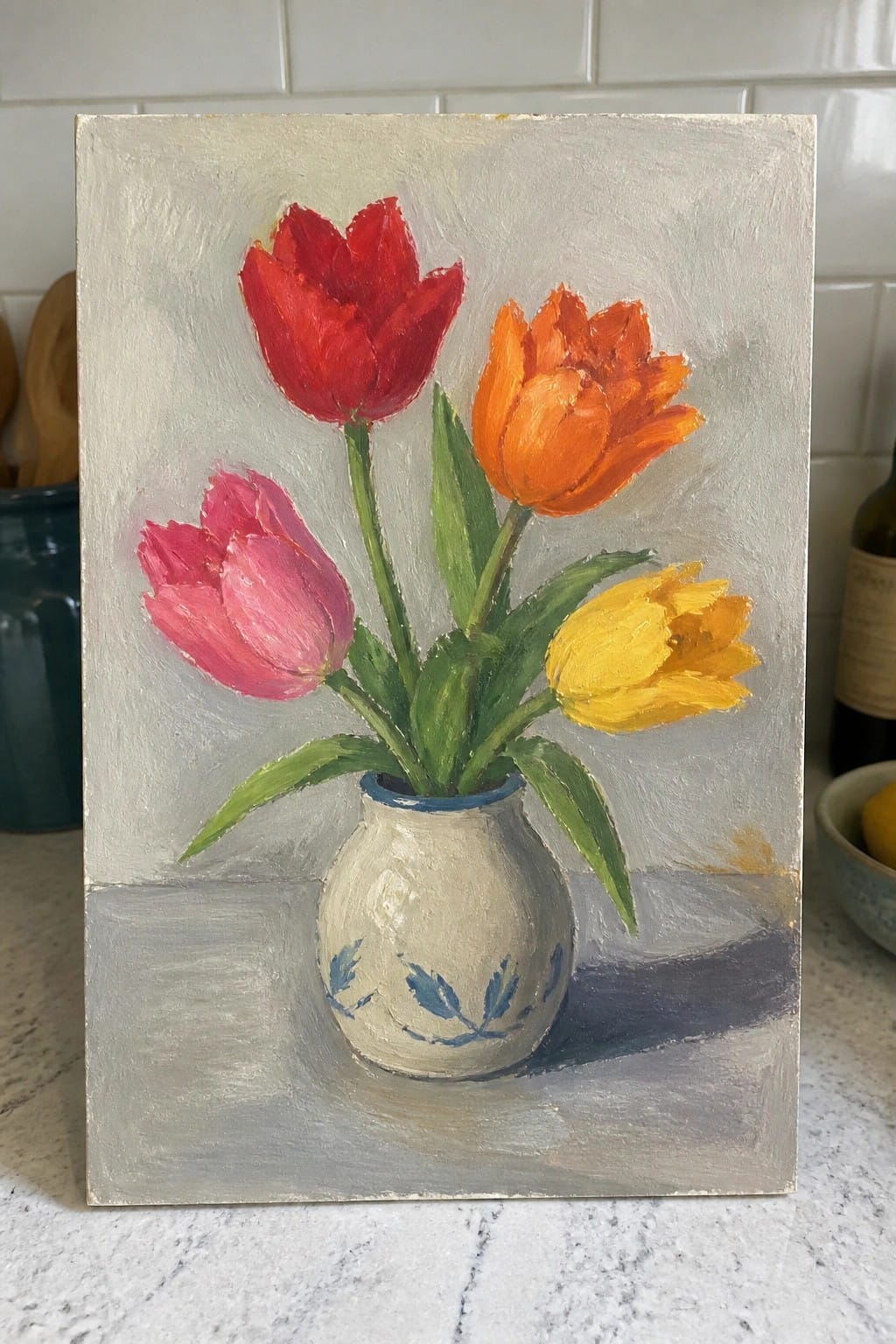 Still-life painting of red, pink, orange, and yellow tulips in a white vase.