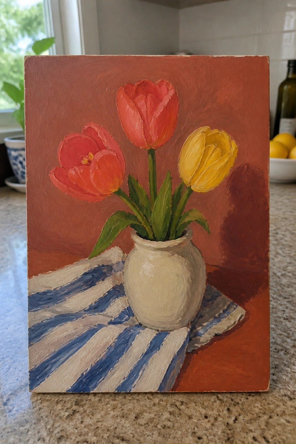 Vibrant painting of two red tulips and one yellow tulip in a white vase on striped cloth.