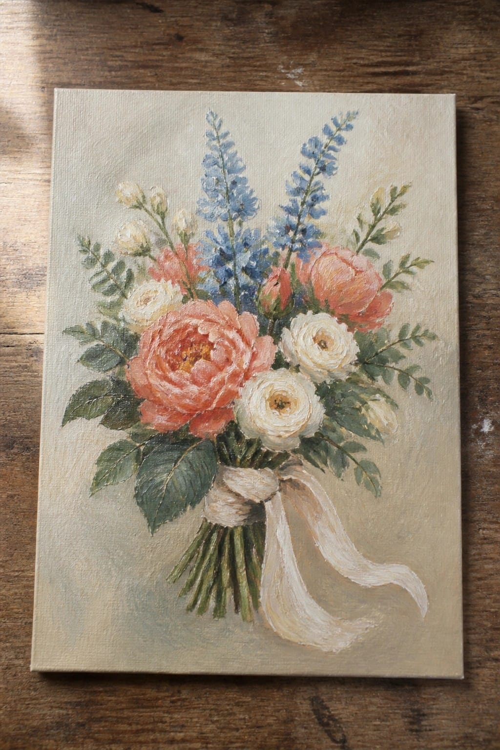 Oil painting of pink peonies, white roses, and blue flowers tied with ribbon.