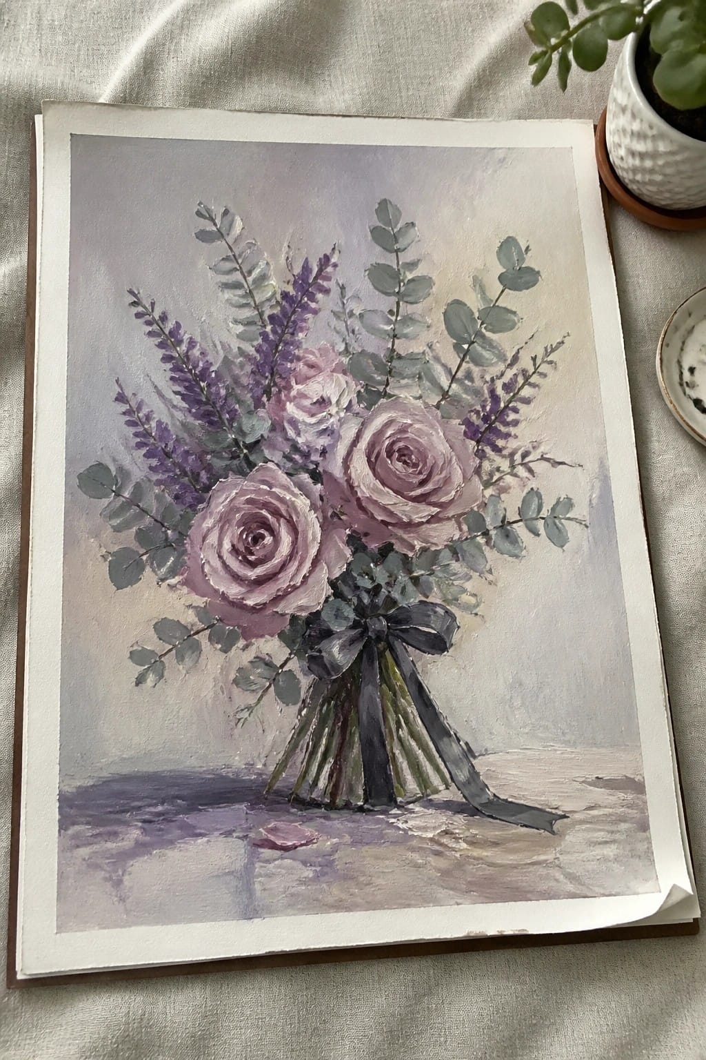An oil painting of a bouquet of purple roses with eucalyptus and lavender tied with a dark ribbon against a soft background.
