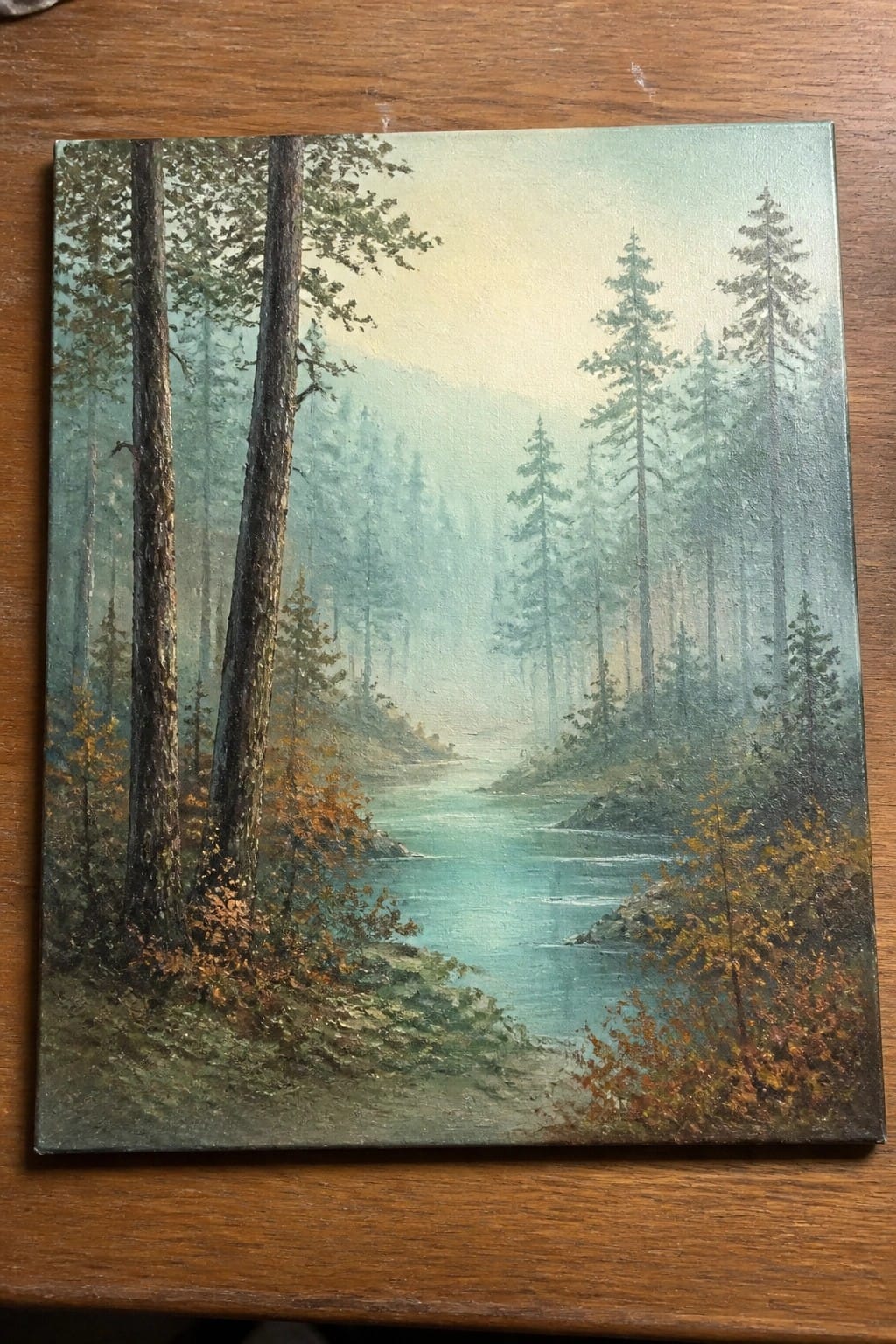 Misty pine forest with turquoise river winding between tall trees and autumn foliage