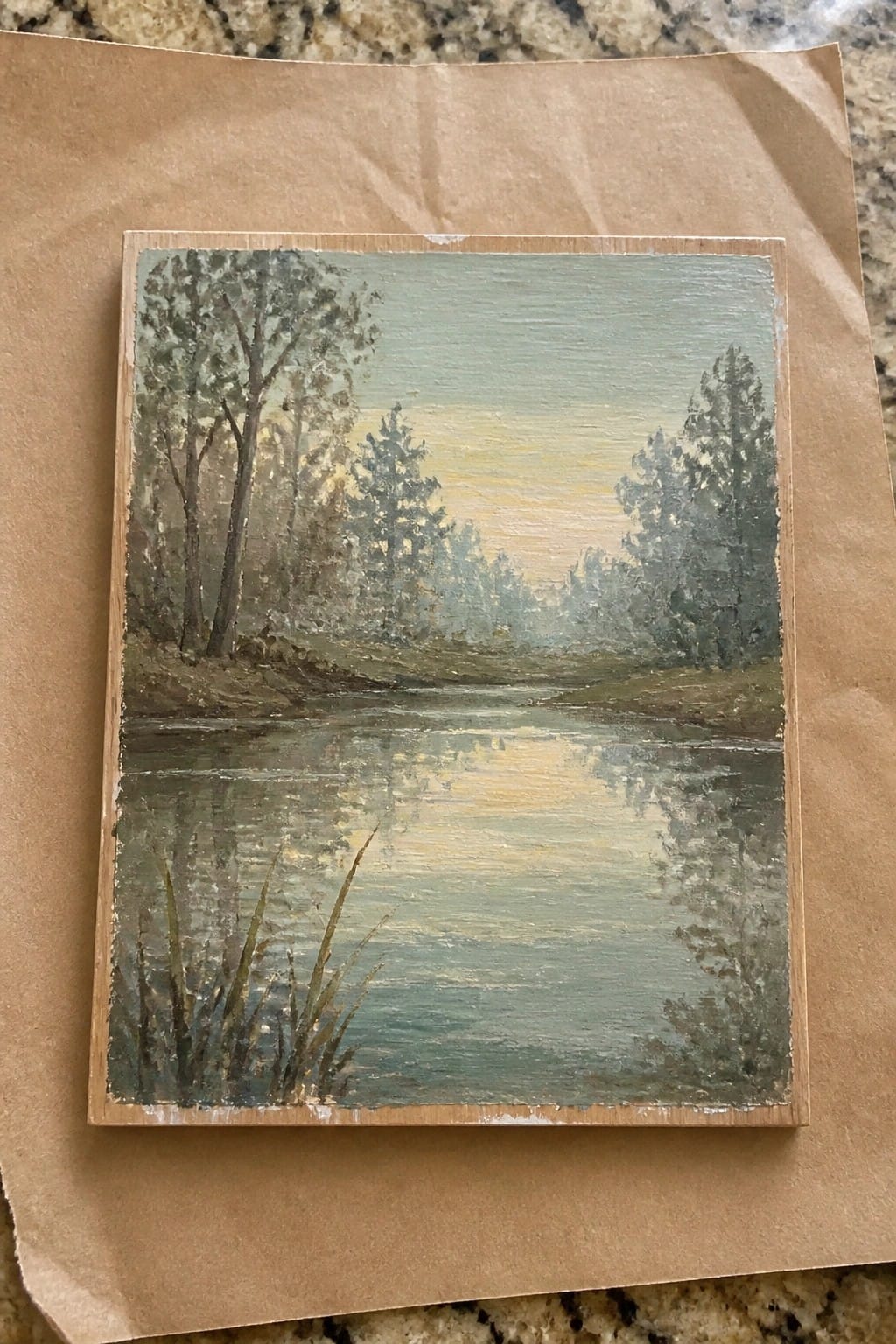 Oil painting of misty river with trees and golden reflections on wooden panel