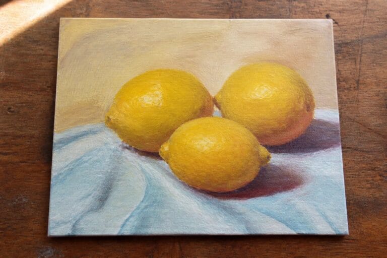 20 Foolproof Oil Painting Ideas on Canvas for Absolute Beginners Three yellow lemons on blue fabric with soft shadows in oil painting.