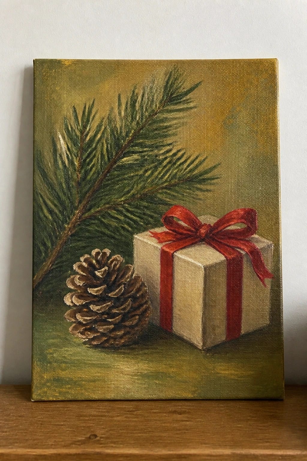 Painting of pine branch, pinecone, and beige gift box with red bow