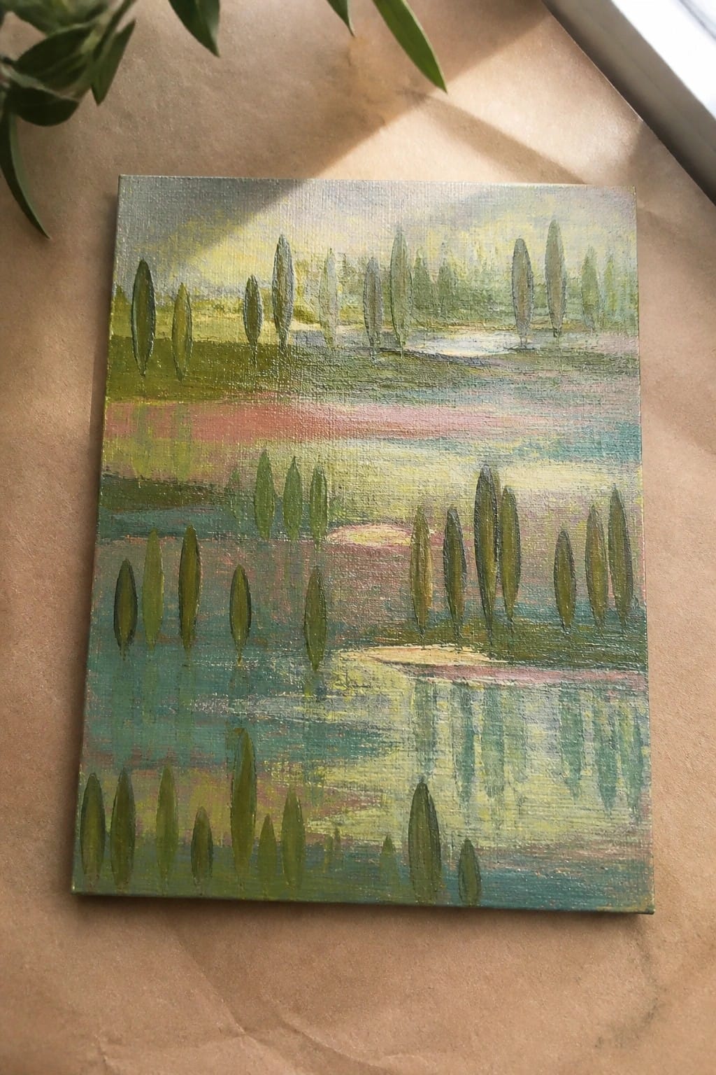 Impressionistic landscape painting with green trees reflected in layered pink and blue water