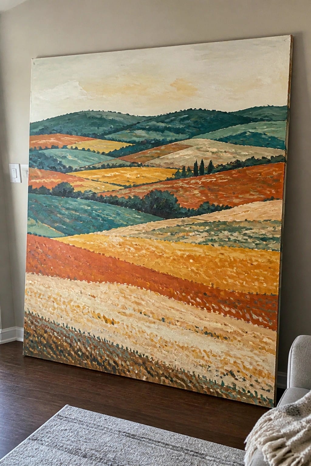 Large vibrant painting of rolling colorful fields and hills on beige wall
