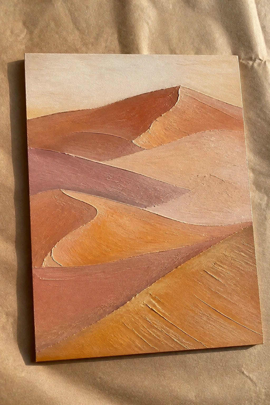 An abstract oil painting of layered rolling hills in shades of brown, orange, and beige on a canvas.