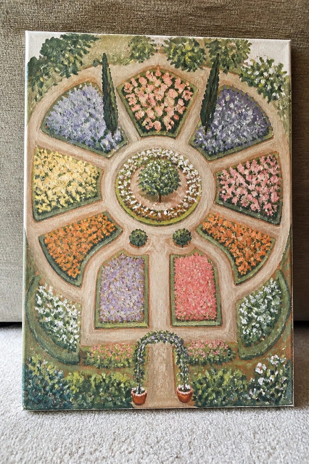 Vibrant painting of a circular formal garden with colorful flower sections and central tree.