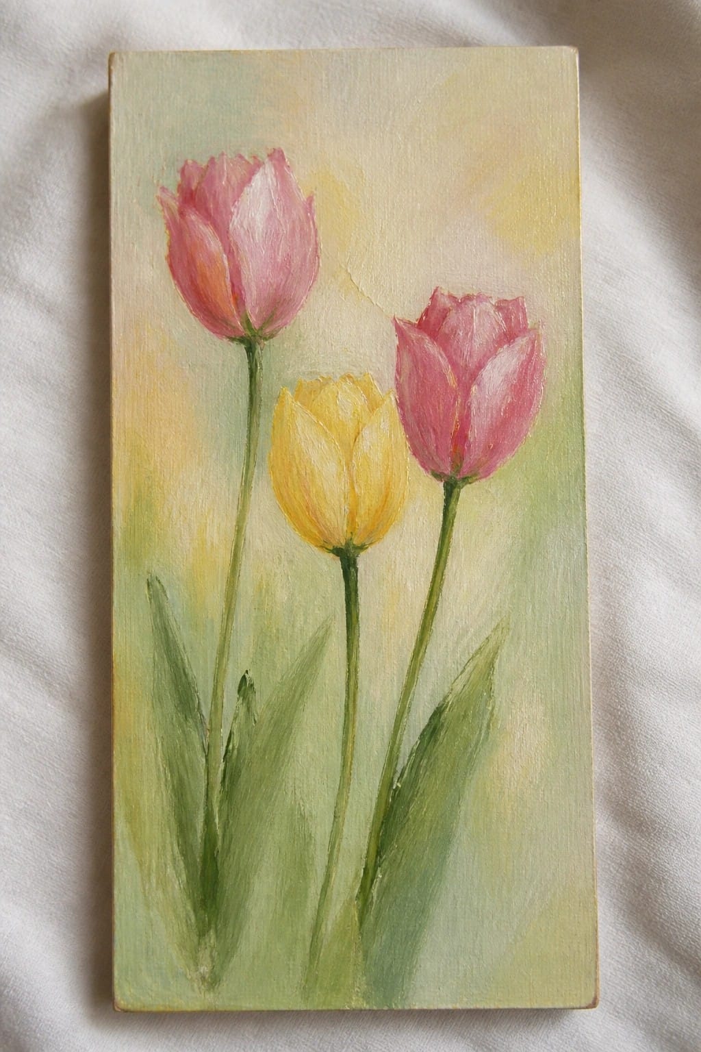 Pastel painting of two pink tulips and one yellow tulip with green stems