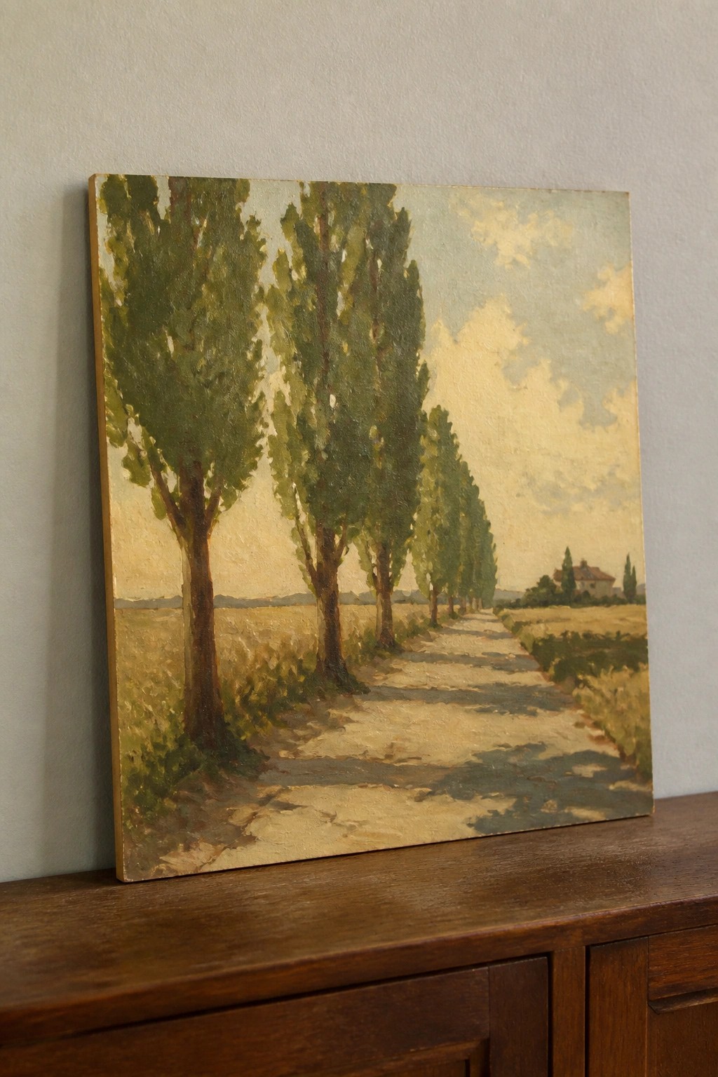 Oil painting of tall trees lining a dirt path through golden fields to a distant house.