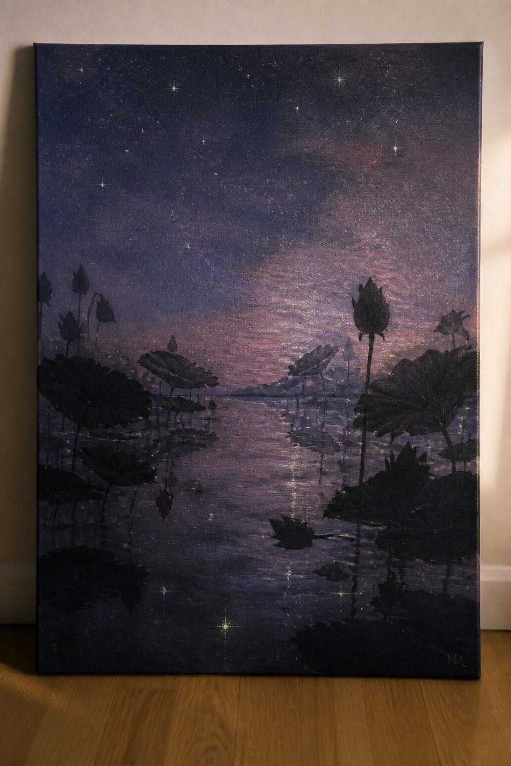Starry purple night sky reflected in a pond with silhouetted lotus plants