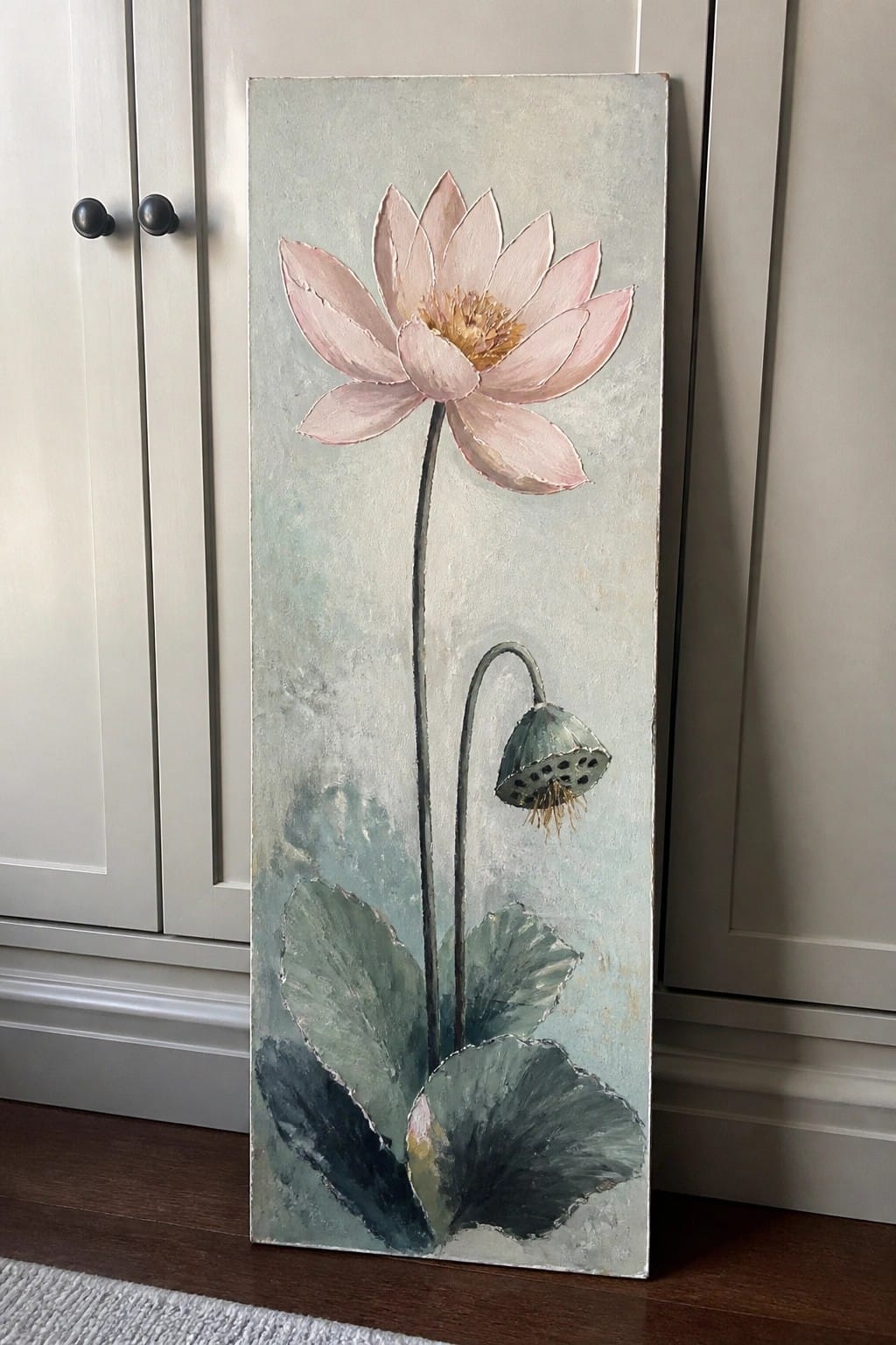 Vertical painting of pink lotus flower with green leaves and seed pod on light blue background.