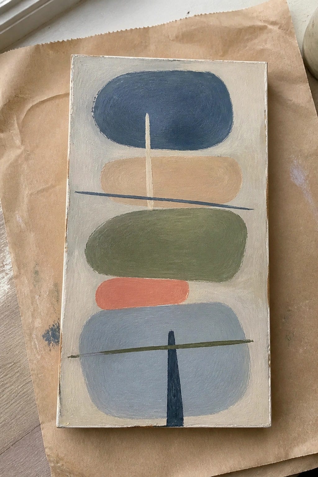 Abstract painting with stacked ovals in blue, green, orange, and gray crossed by lines