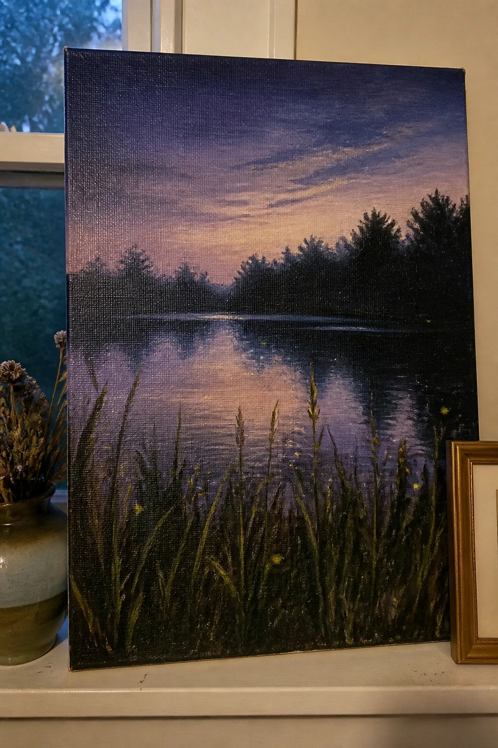 Twilight landscape painting with purple-orange sky, reflective water, silhouetted trees, and foreground grasses.