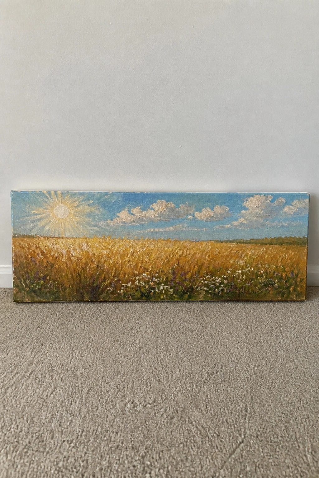 Oil painting of golden wheat field under bright sun and blue sky with clouds.