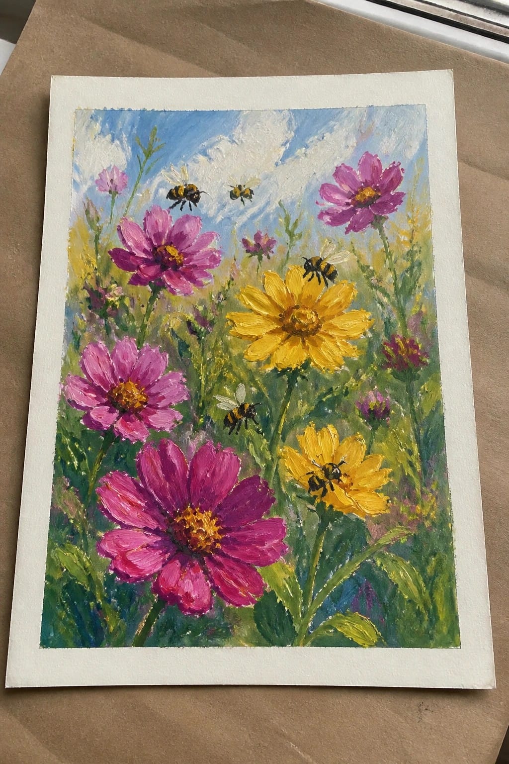 Vibrant painting of pink and yellow wildflowers with bees under a blue sky