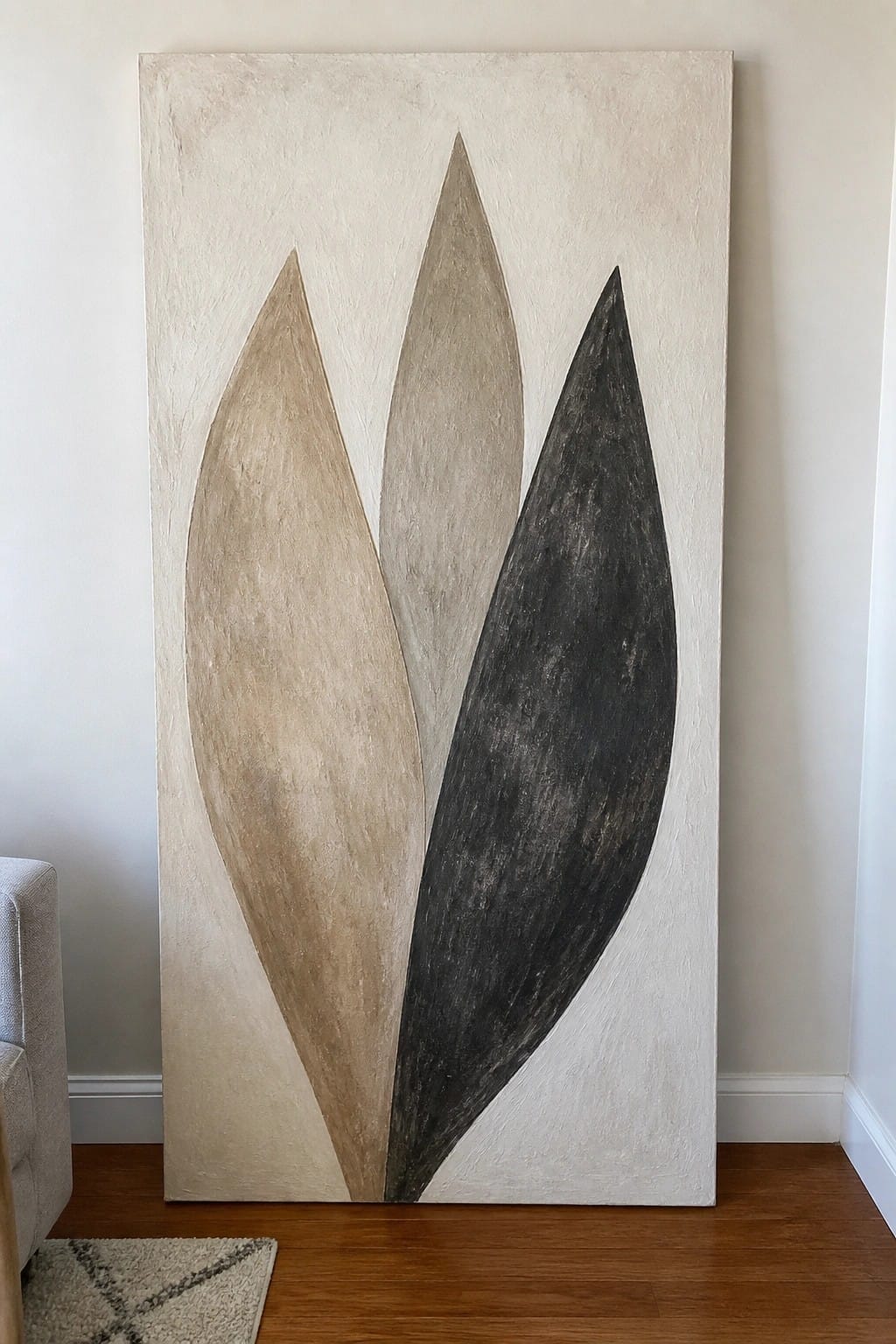 Abstract painting with three elongated shapes in beige, gray, and black on white canvas