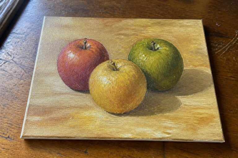 An oil painting of a red apple, a yellow apple, and a green apple on a wooden surface.