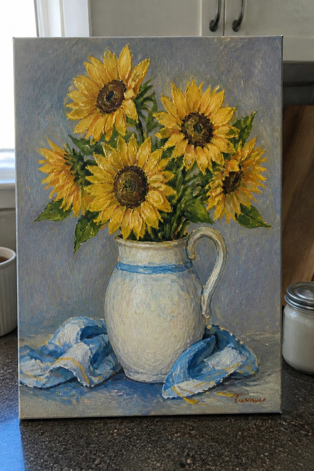 Sunflowers in a white pitcher with blue stripe on draped blue cloth