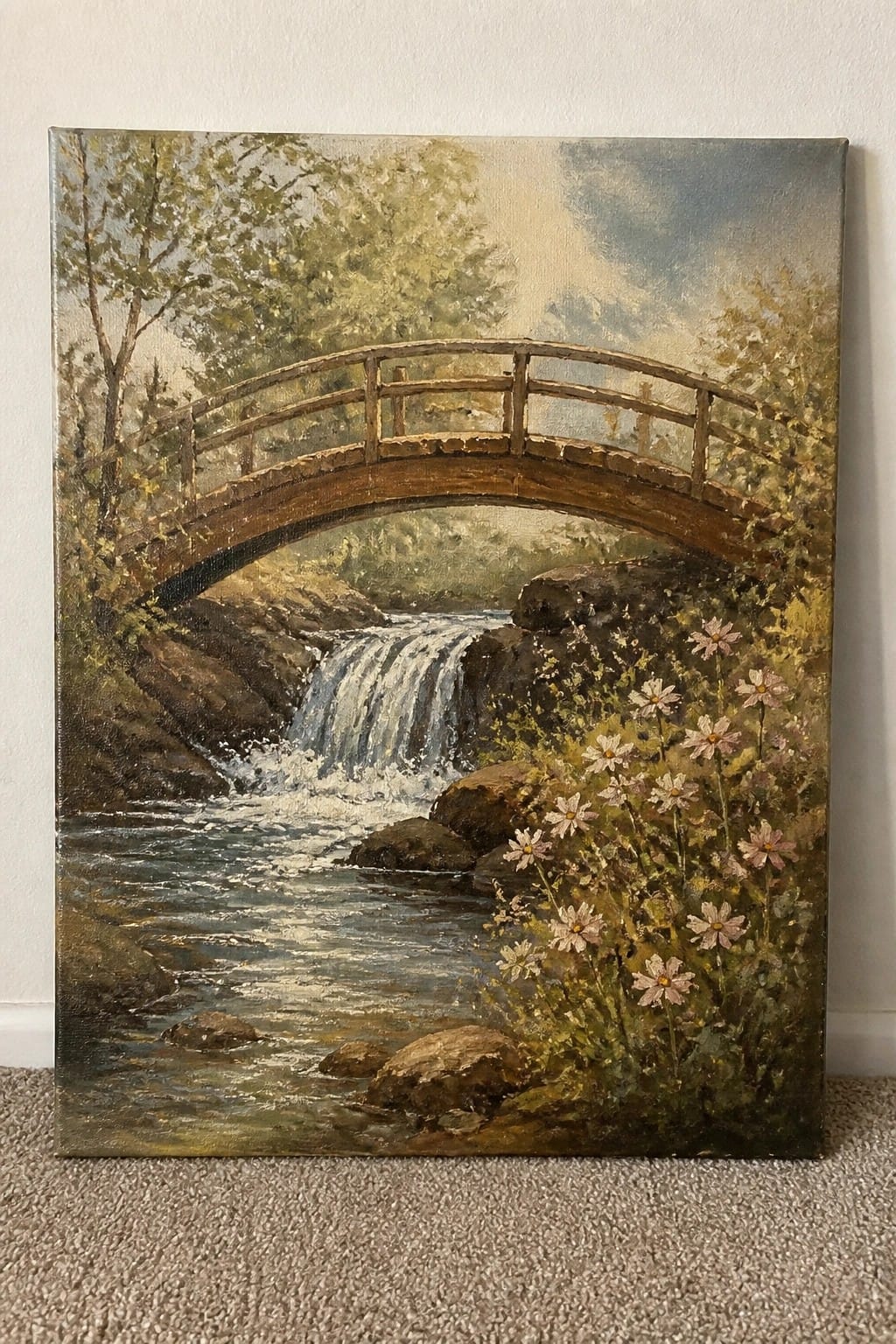 Painting of arched wooden bridge over rocky stream with waterfall, trees and pink flowers.