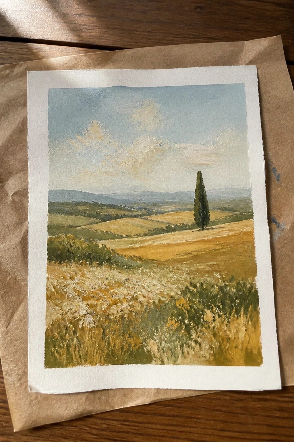 Painting of golden fields, rolling hills, and a lone cypress under blue skies.