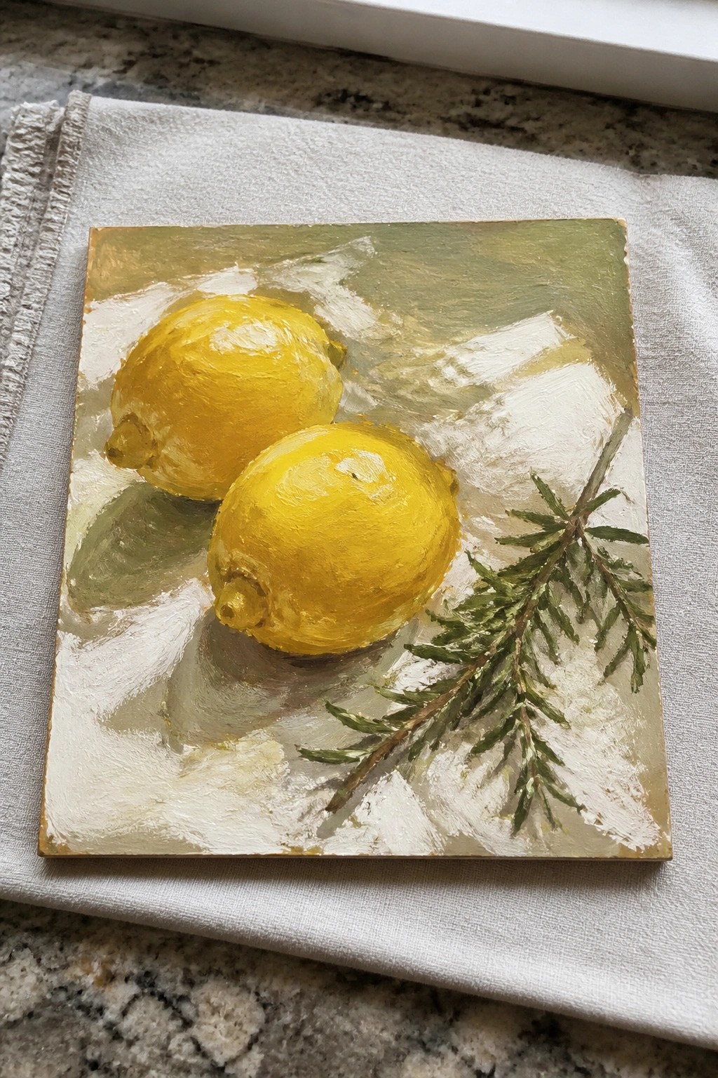 Two yellow lemons and a green sprig on a textured white-green canvas