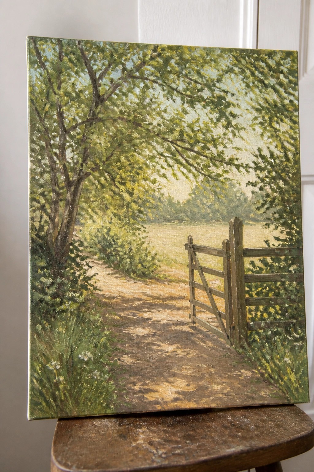 Oil painting of sunlit dirt path through green trees to wooden gate in field