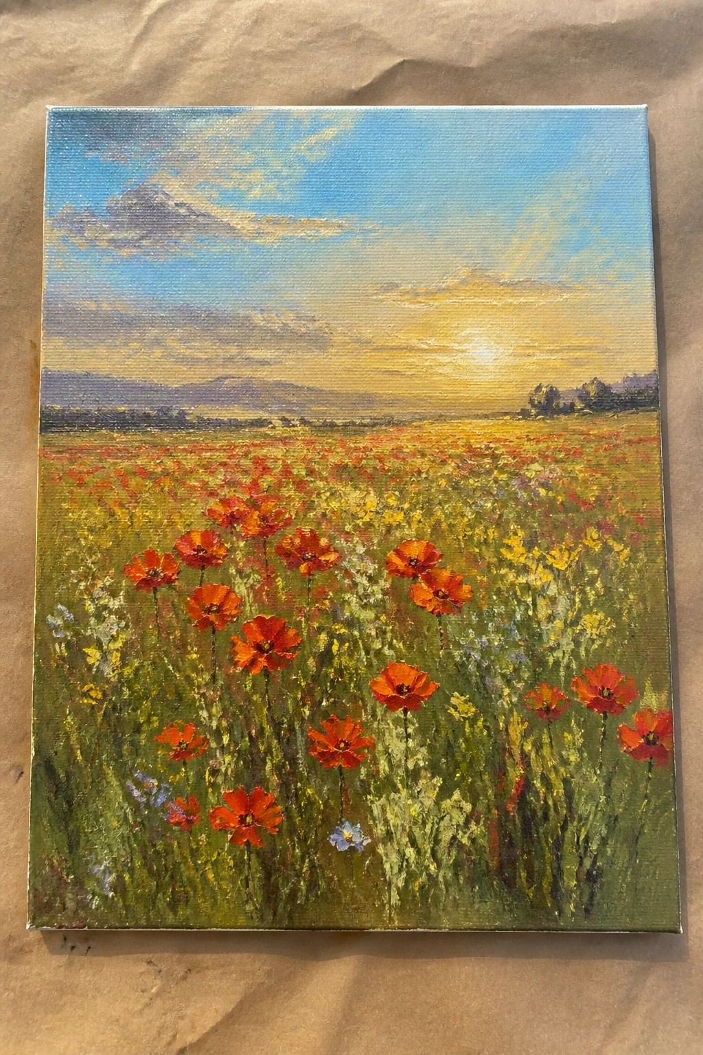 Vibrant oil painting of red poppies blooming in a sunlit meadow at sunset.