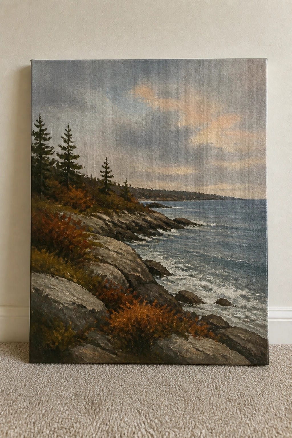 Rocky coastal landscape painting with autumn trees, gray rocks, and ocean waves under cloudy sky