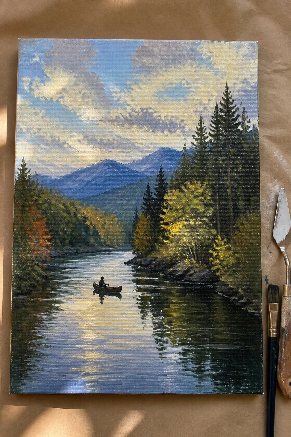Oil painting of person in canoe on sunlit river with autumn trees and mountains