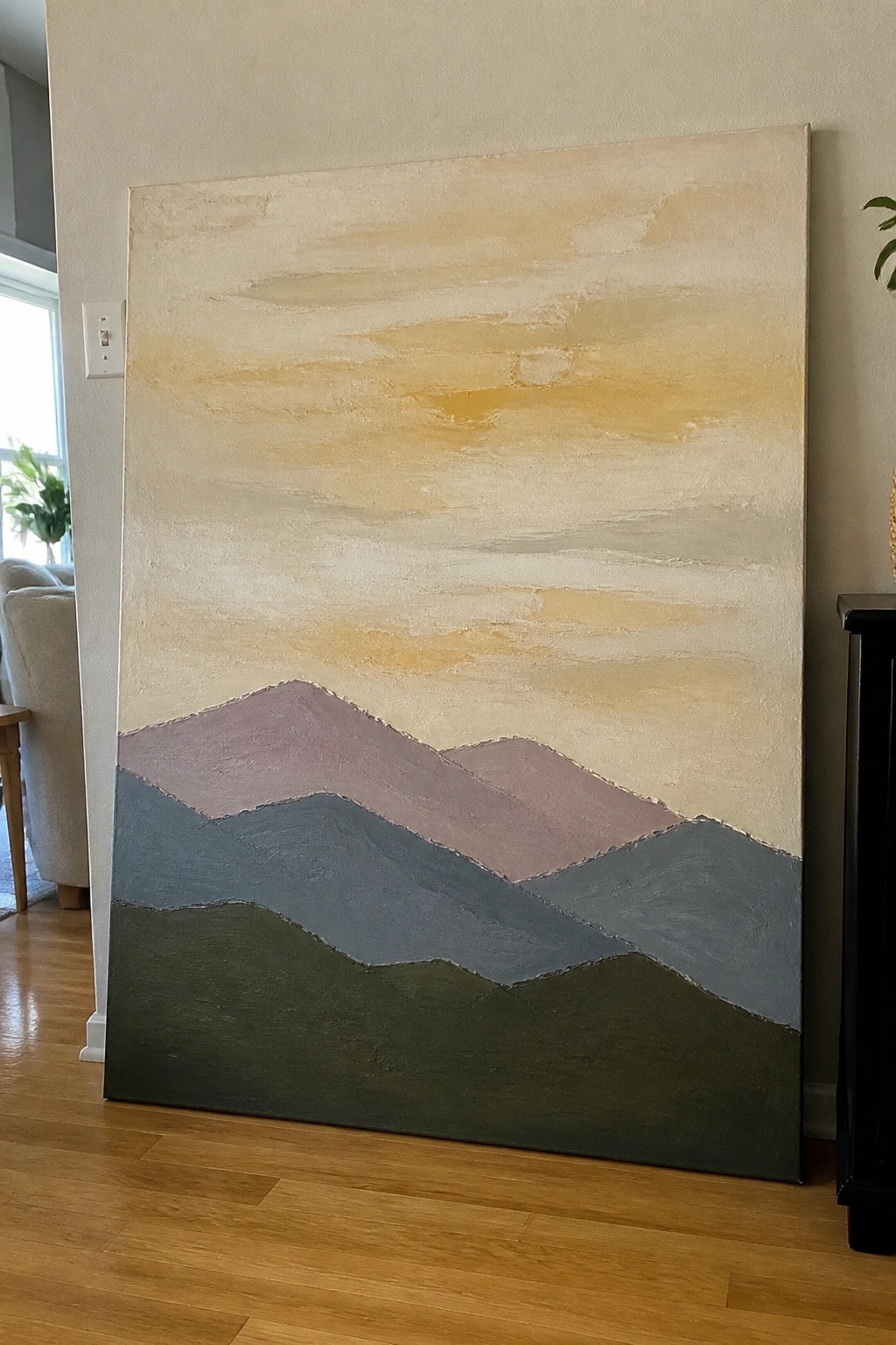 Large abstract painting of layered green, blue, and purple mountains under a warm yellow sky.