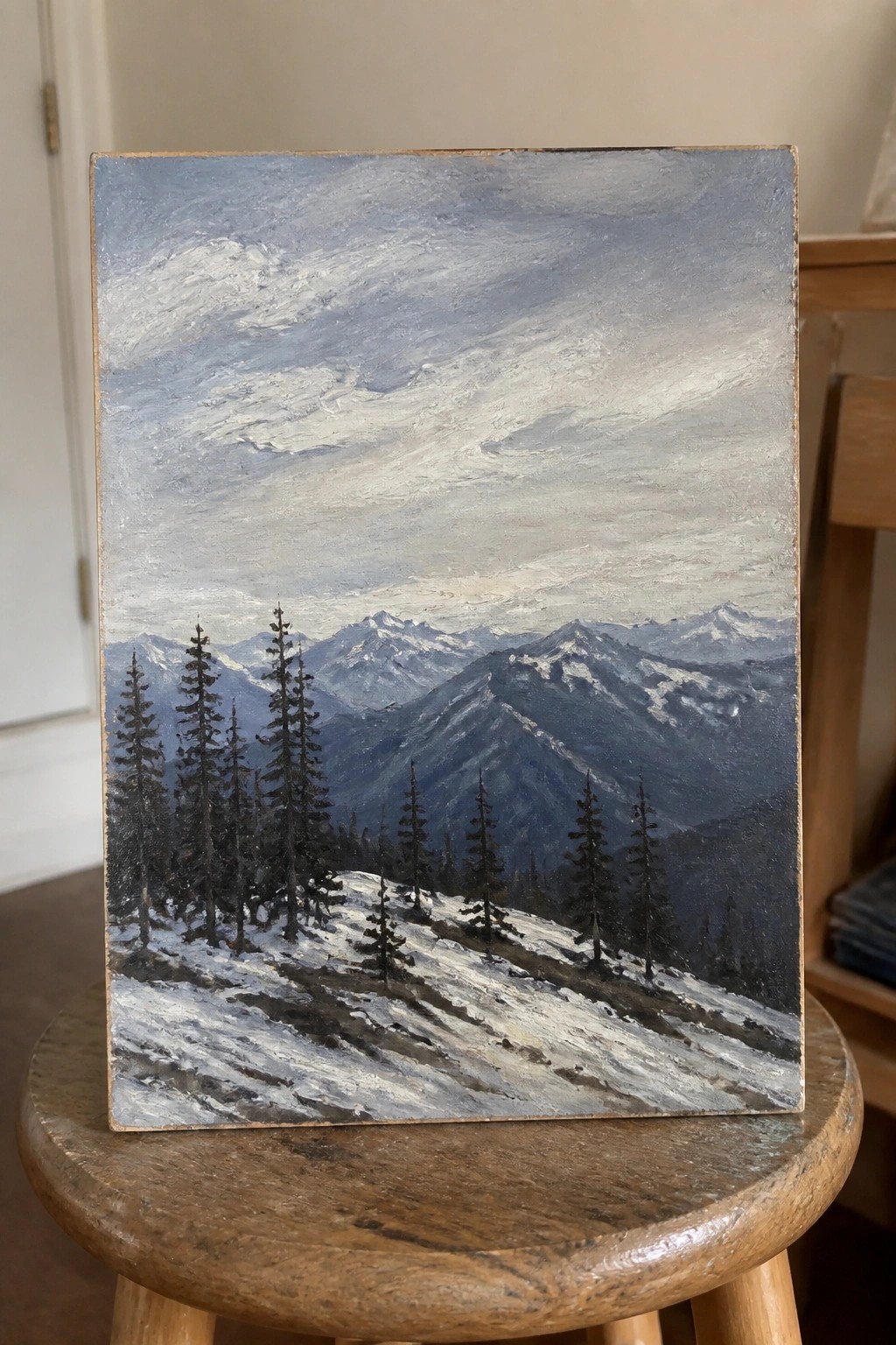 Oil painting of snowy mountain landscape with pine trees on wooden stool