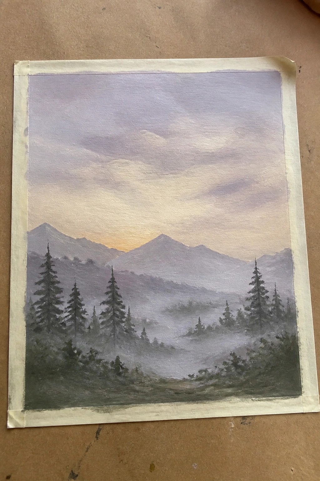 Misty layered mountains at sunset with silhouetted pine trees and fog-filled valleys