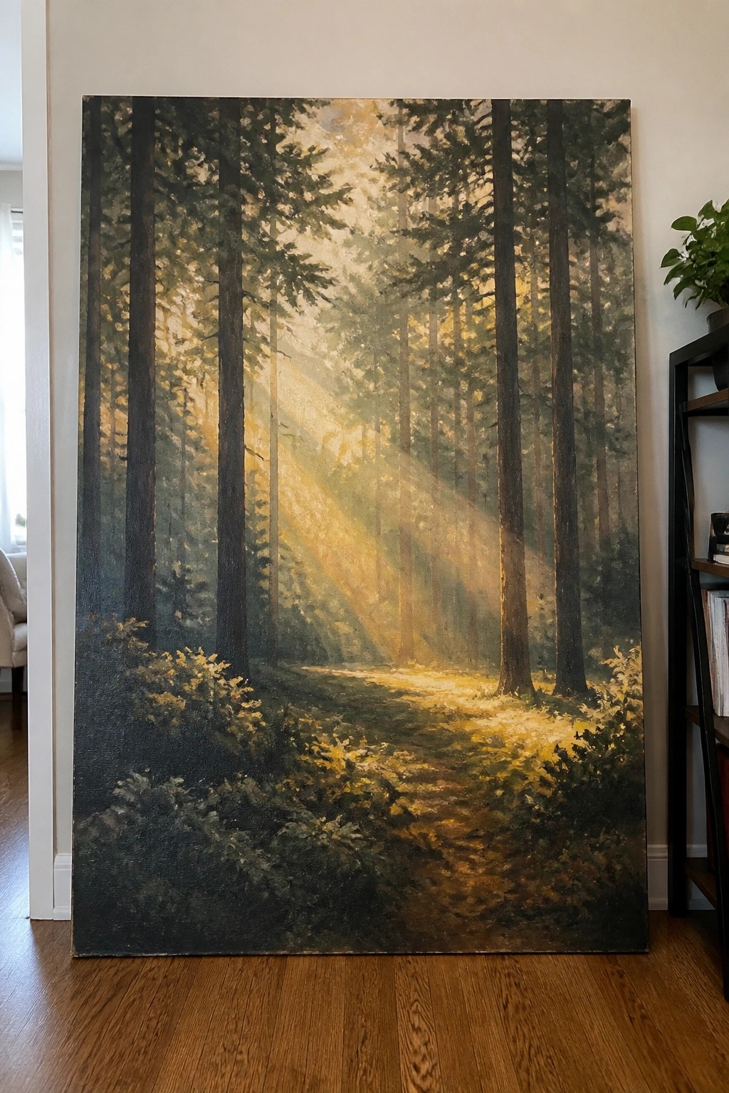 Large painting of sunlit forest path with golden rays through tall trees, indoors on wooden floor