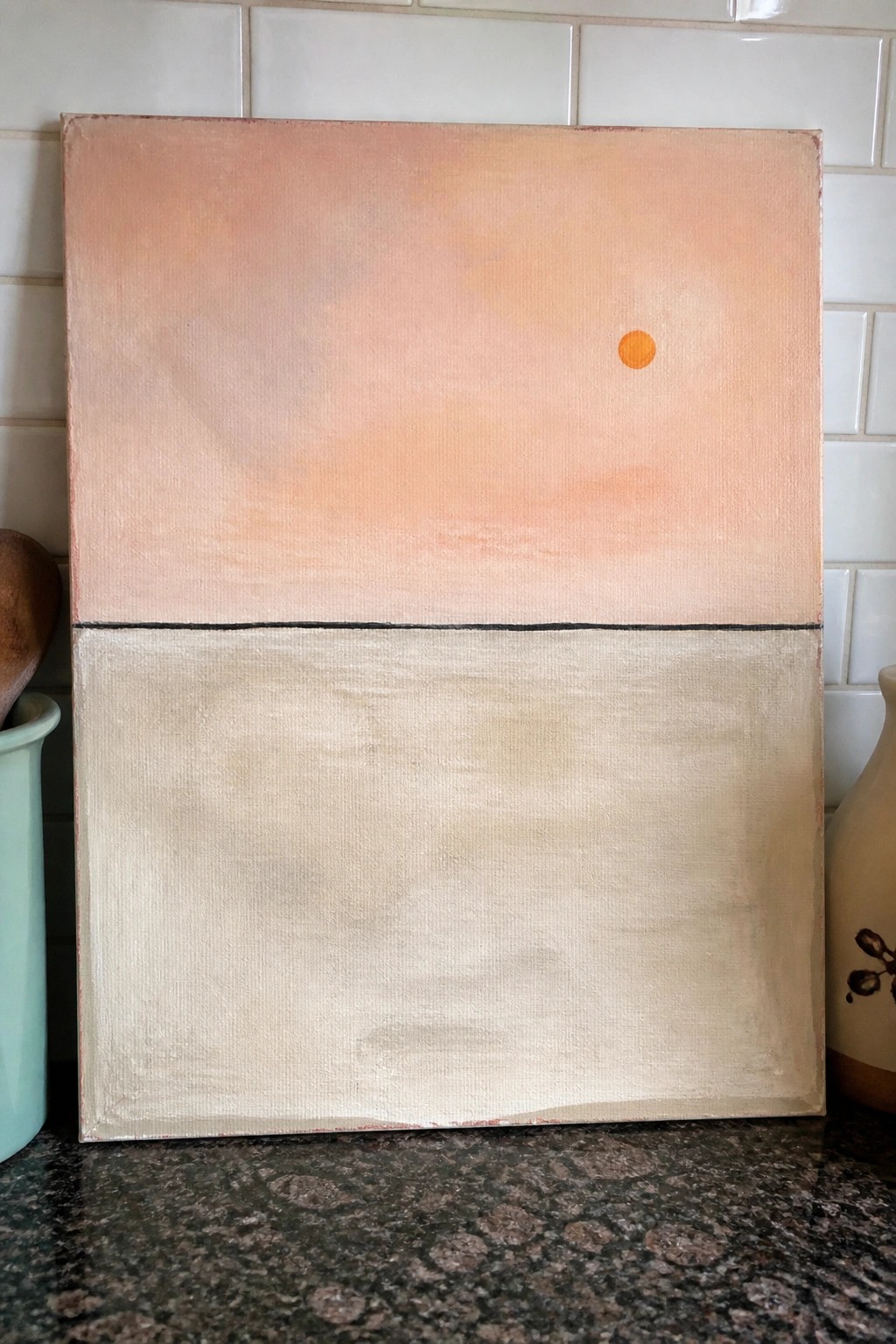 Abstract painting of peach sky with orange dot above beige lower half divided by black line