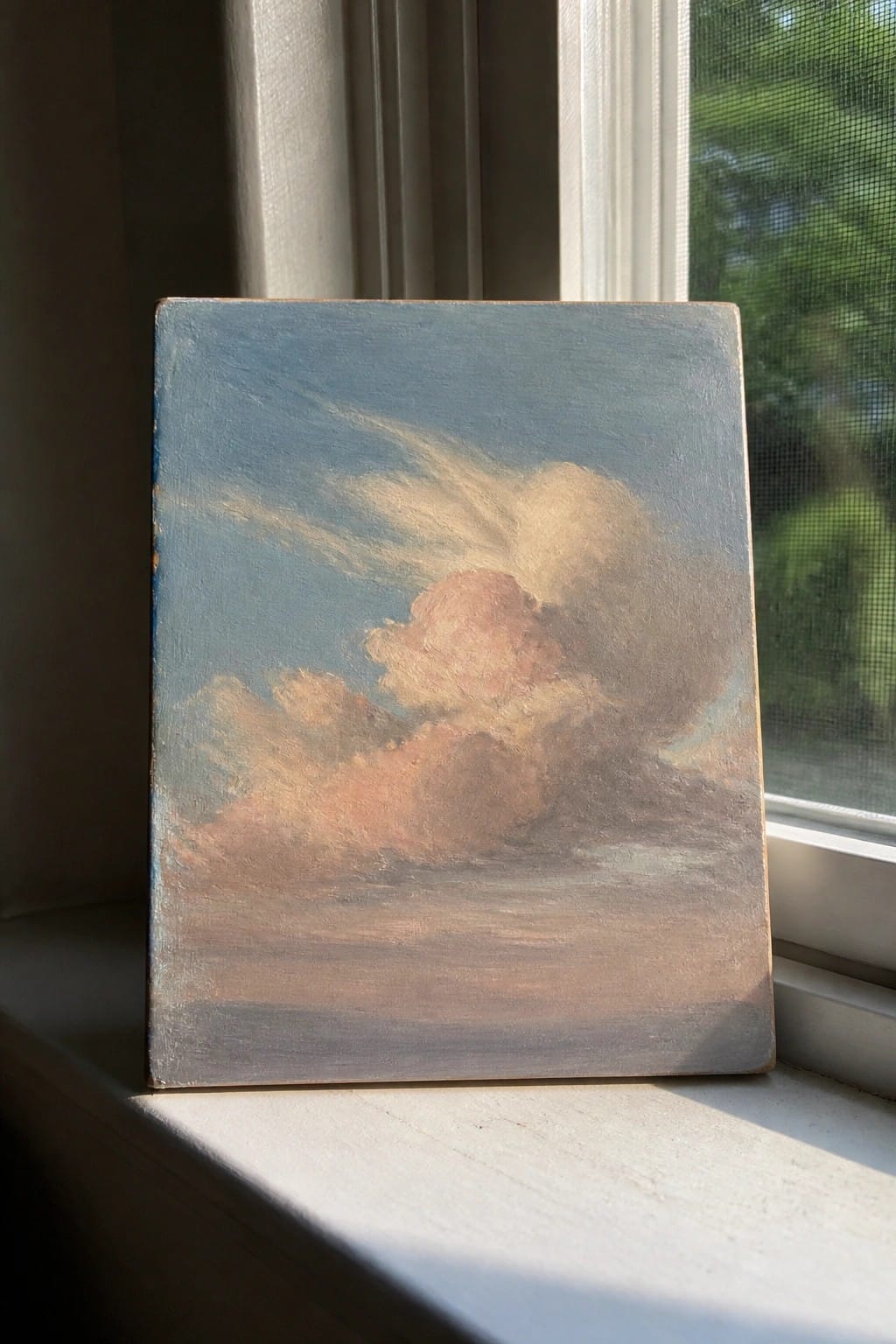 Small canvas of pink and blue clouds on a sunlit windowsill.