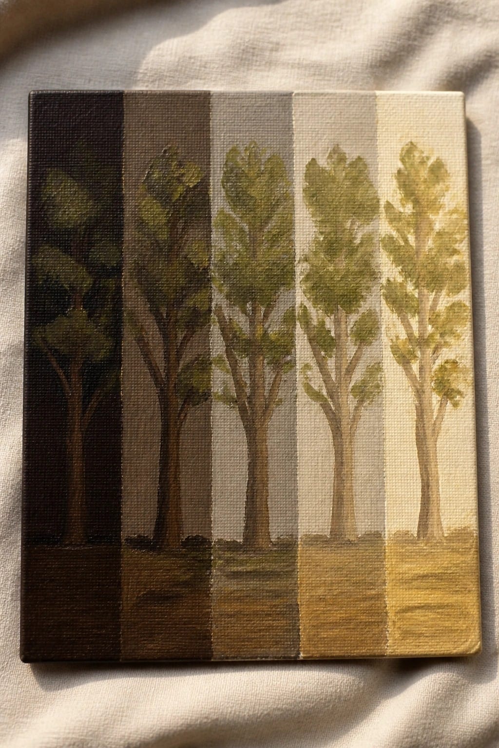 Canvas painting of five trees fading from dark to light on white fabric