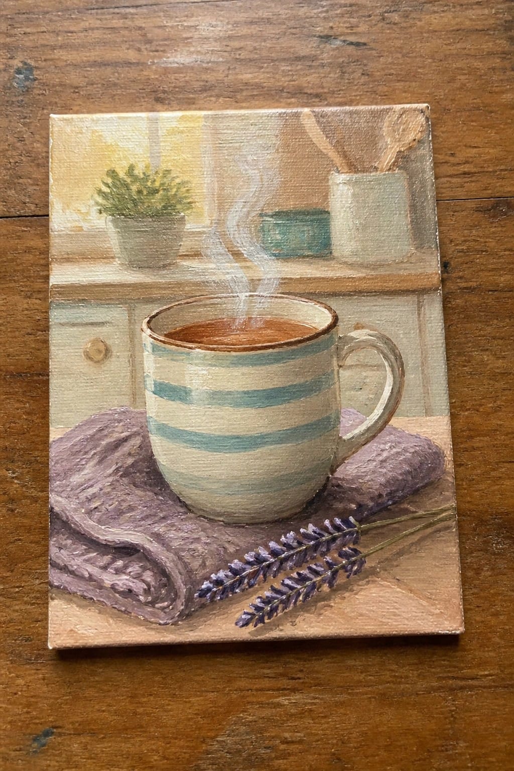 Steaming striped mug on purple cloth with lavender sprigs in painted kitchen scene