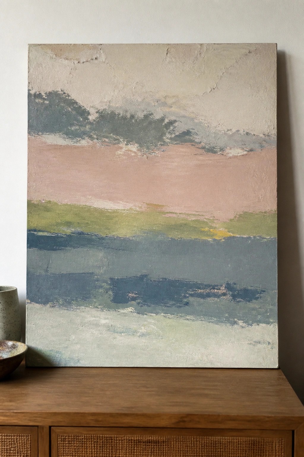 Abstract painting with horizontal pastel bands above wooden cabinet with pottery vessels