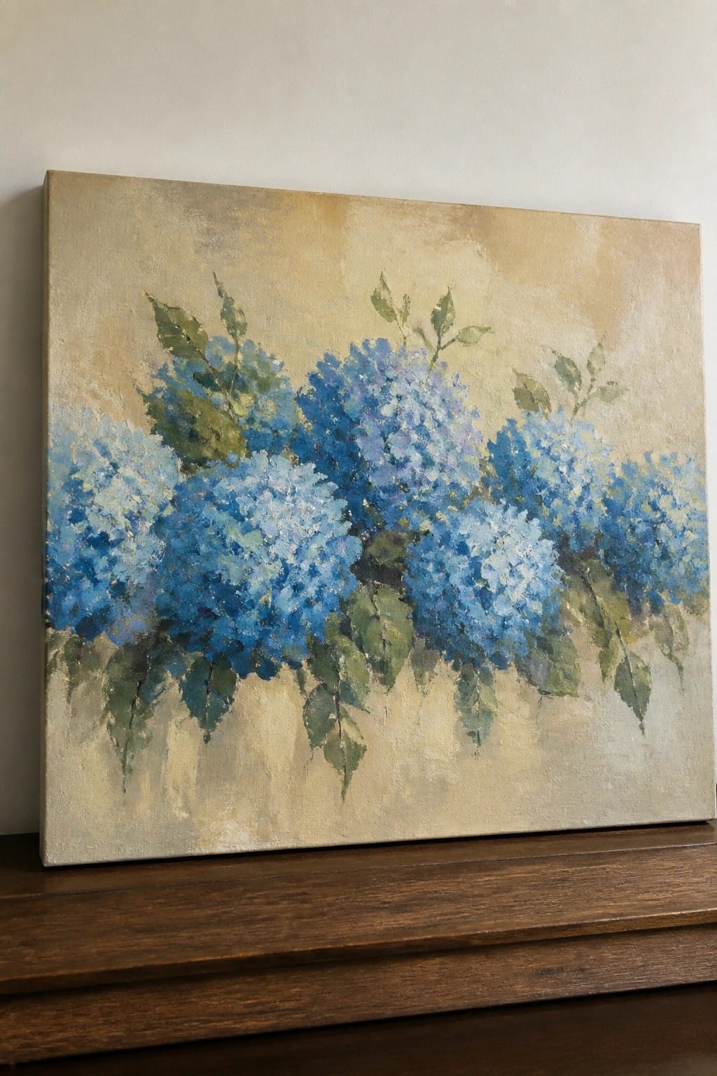 Oil painting of blue hydrangeas with green leaves on a beige background