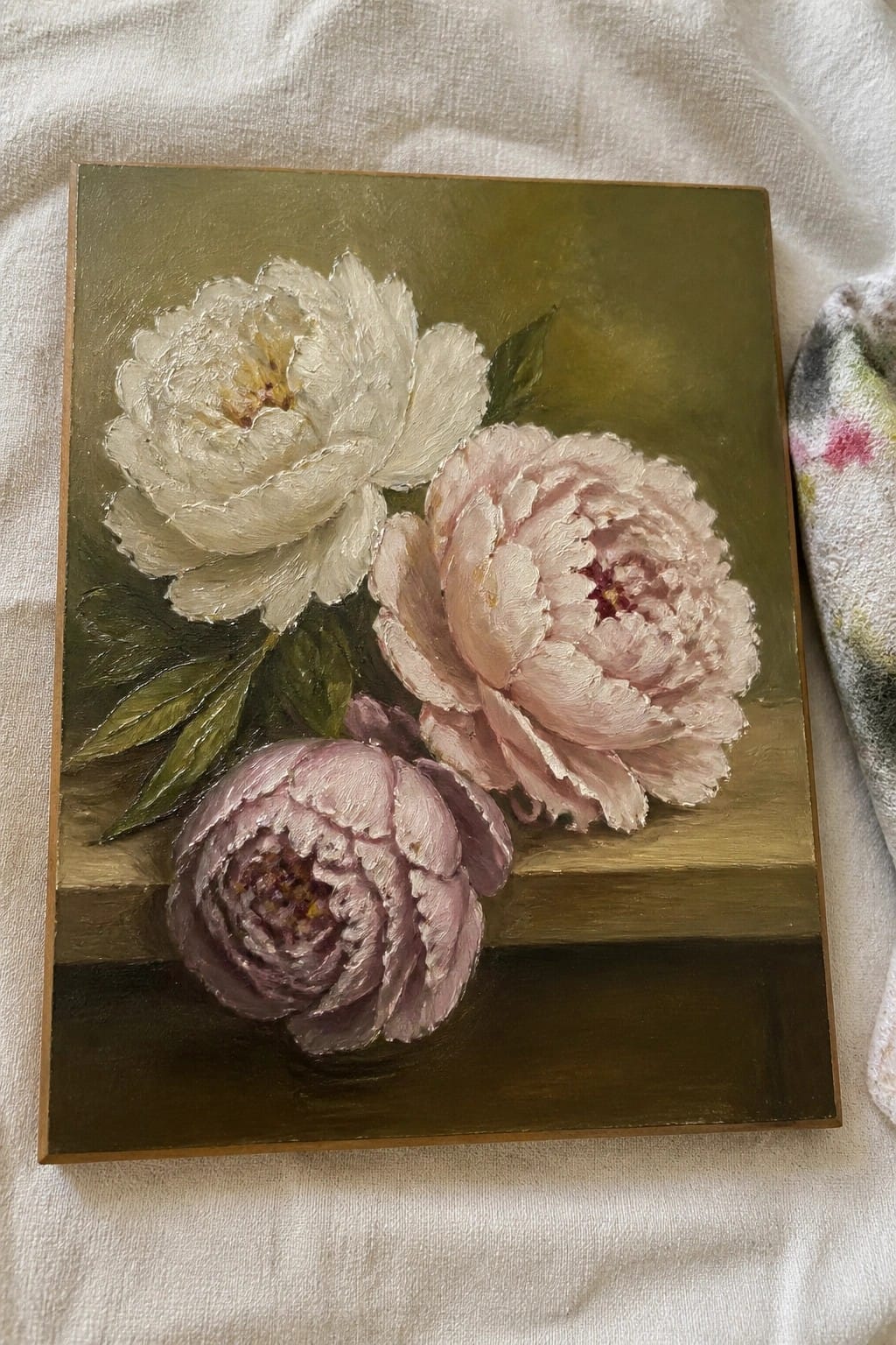 Textured oil painting of white, pink, and purple peonies on green and brown background.