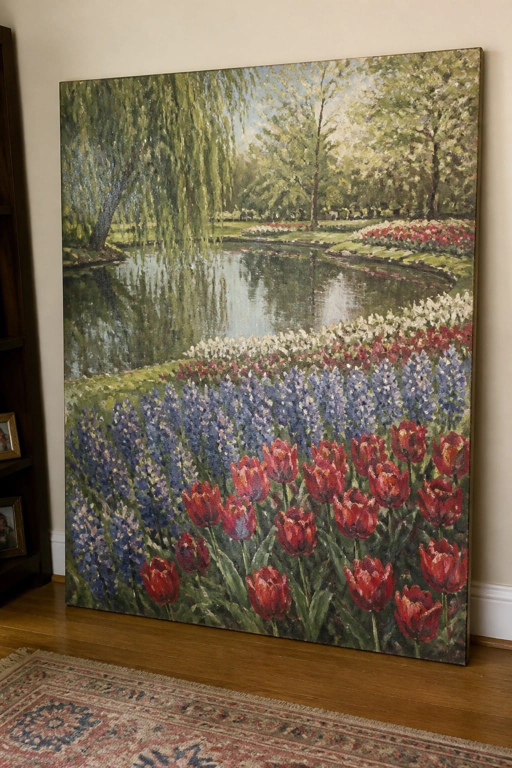 Large oil painting of red tulips by a pond with weeping willows and blue flowers