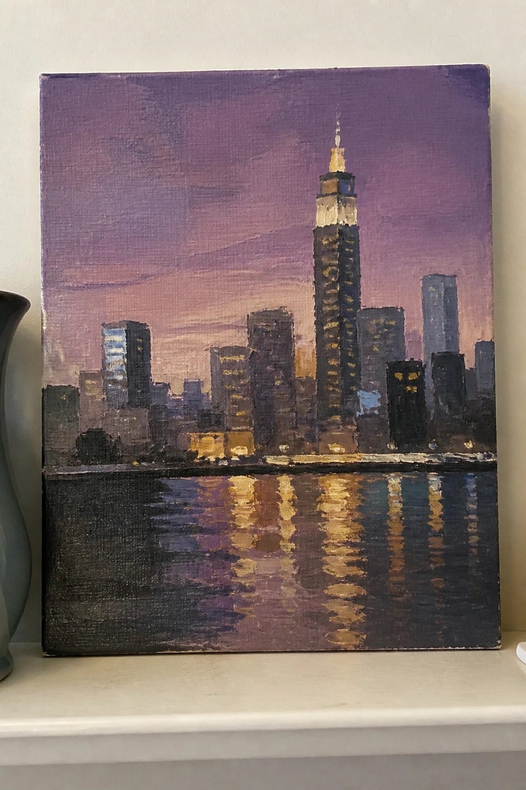 Oil painting of illuminated skyscrapers and spire reflected in dark water under purple sky