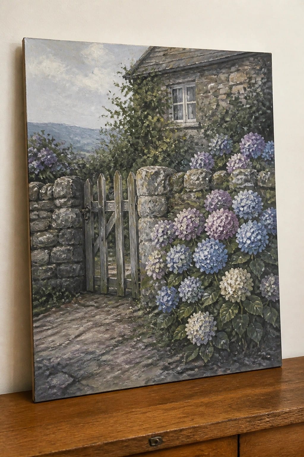 Oil painting of stone cottage with blue-purple hydrangeas, wooden gate, and cobblestone path.