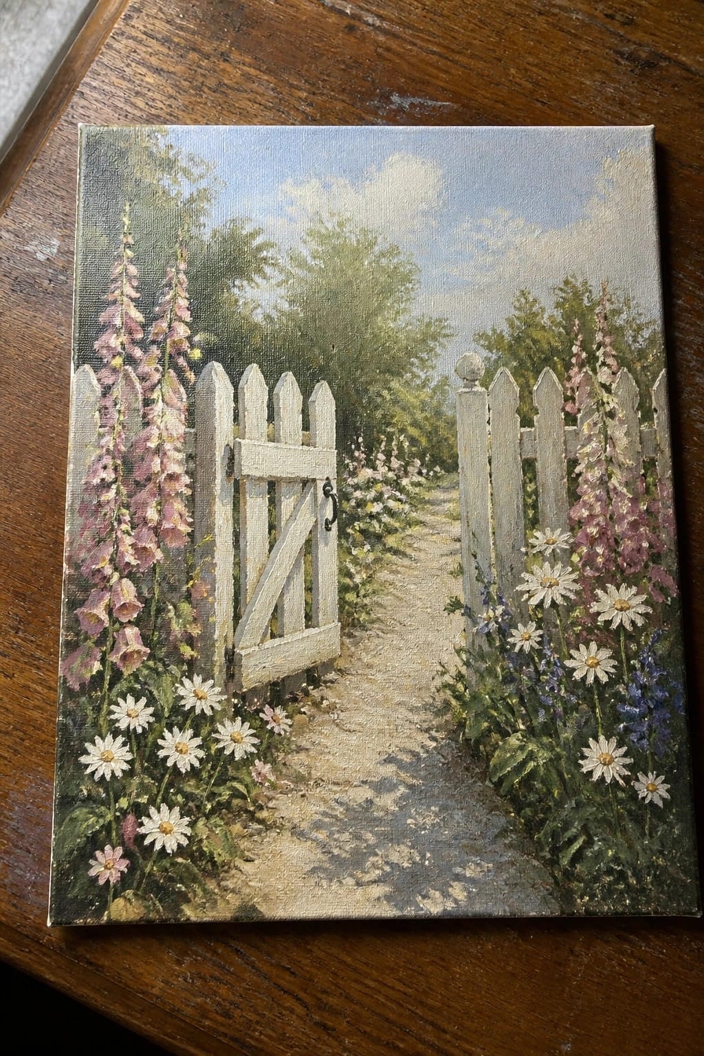 Ajar white picket gate on path lined with pink foxgloves and daisies