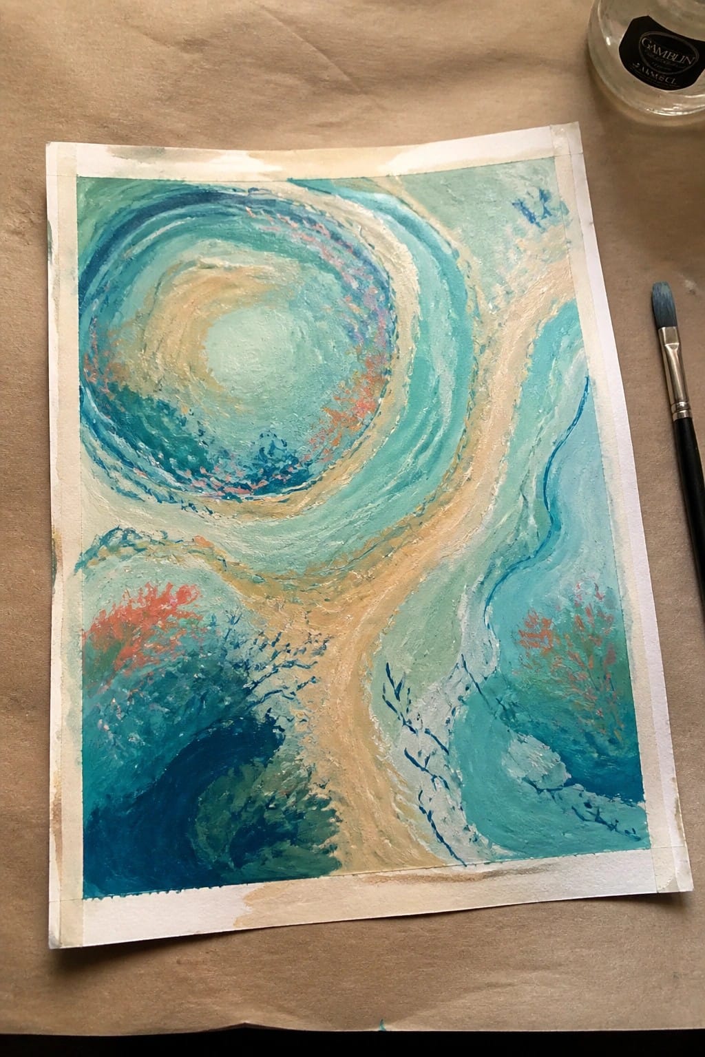 Abstract swirling painting in teal, blue, and beige with red accents beside paintbrush.