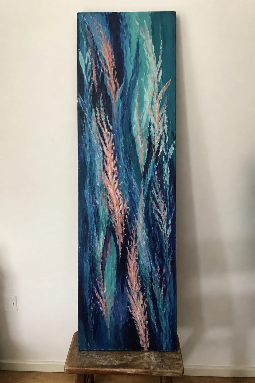 Tall abstract painting of pink coral in blue and teal tones on wooden stool