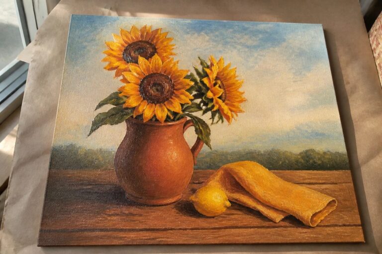 Oil painting of two sunflowers in terracotta pitcher with lemon and yellow cloth on wood table